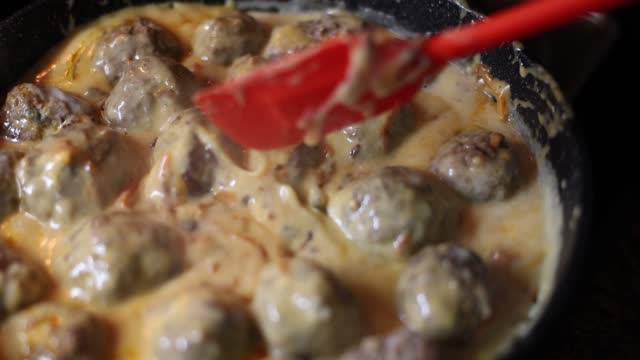 Delicious homemade meatballs with creamy sauce in frying pan