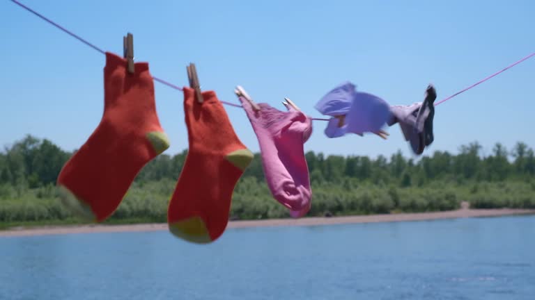 multicolored clean socks after washing are dried on rope with clothespins. soft focus. slow motion.