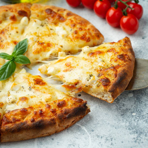 istock Italian pizza four cheeses with stretching cheese and basil on a light concrete background 1471773303