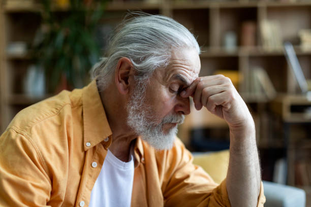 istock Side view of sad elderly man touching his nose bridge 1471775238