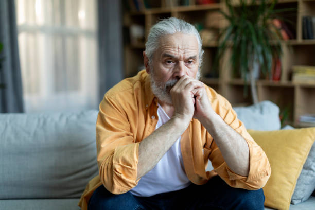 istock Pensive senior man sitting on couch alone, home interior 1471775240