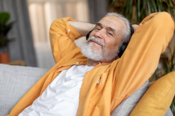 istock Good-looking elderly man enjoying newest wireless headset at home 1471775241