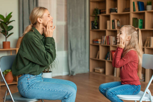 istock Speech practice. Girl preschooler training with professional speech specialist, repeating oral exercises 1471775551