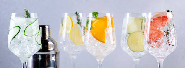 istock Gin tonic cocktails set. Trendy drinks with lime, lemon, grapefruit, orange, cucumber, soda and spicy herbs in wine glasses, gray background, banner 1471775865