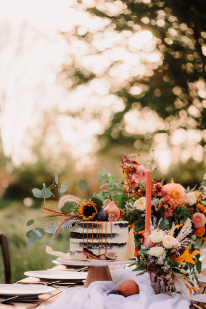 istock Wedding cake and flowers on a table outdoors 1471795236