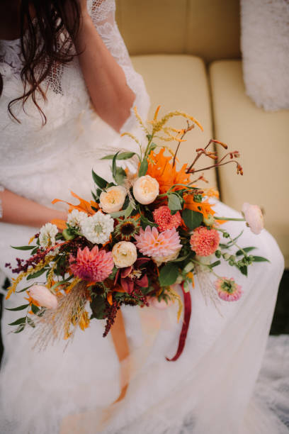 istock Bride holding floral bouquet on her lap 1471799558