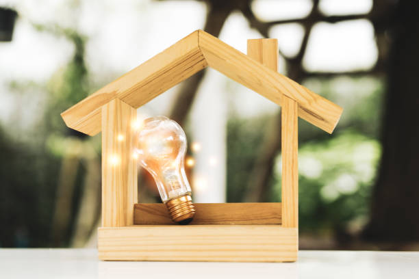 istock Light bulb with wood house on the table, a symbol for construction, Creative light bulb idea, power energy or business idea concept ecology, loan, mortgage, property or home. 1471802639