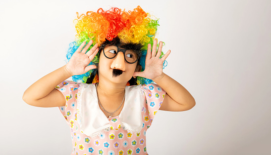 April Fool's Day. Two brothers funny kid little girl clown wears curly wig colorful big nos and glasses and mustache playing fool isolated on white background copy space, Happy child festive decor