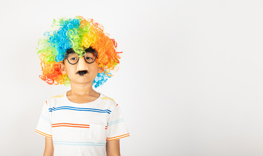 April Fool's Day. Two brothers funny kid boy and little girl clown wears curly wig colorful big nos and glasses and has mustache isolated on white background, Happy children festive decor