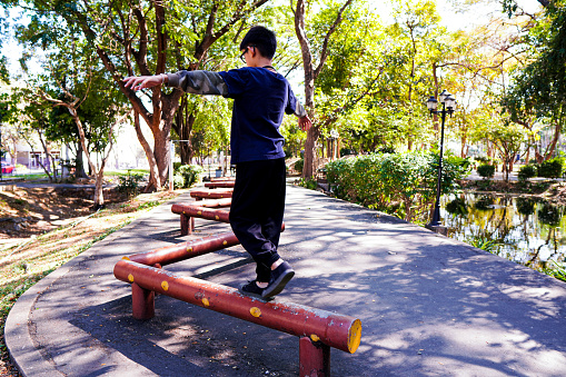 Picture a kid demonstrating his balance training walk or run on a log at a public exercise park.