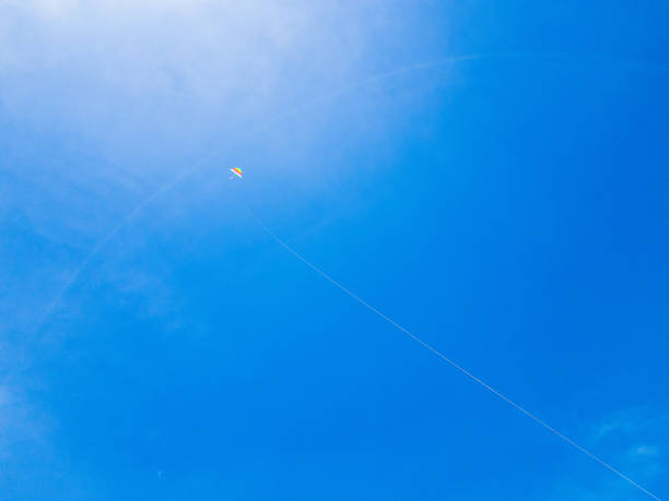 kite flying against a blue sky and sun.