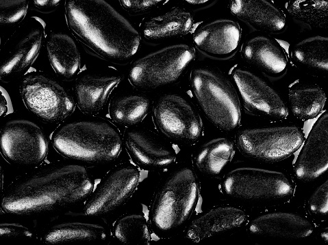 Black river stones texture and background. Black pebbles in water and water drop.