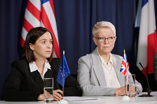 Frustrated businesswoman talking to her colleague while being on a meeting in a board room.