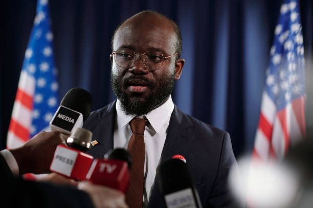istock Young African American delegate talking in microphone at press conference 1471814638