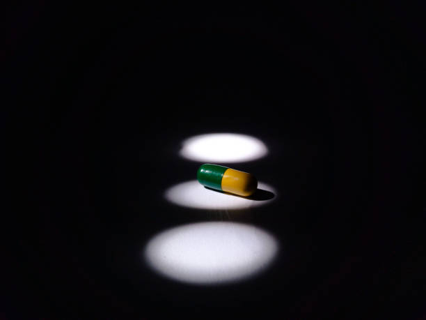 istock Pharmaceutical drug pills, tablets and capsules on black and white background. Copy space. Medicine concept. Minimalist abstract concept. 1471815683