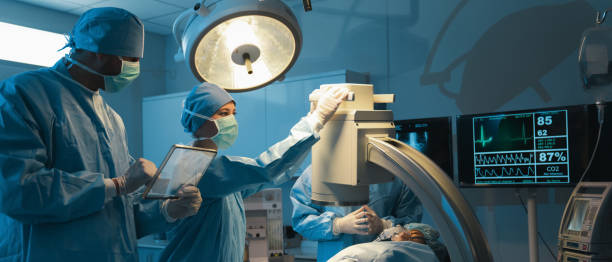 el equipo médico discutió las opciones quirúrgicas con el paciente antes de proceder con la operación. equipo de cirujanos que operan a un paciente en la sala de operaciones del hospital - authority expertise science and technology technology fotografías e imágenes de stock