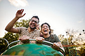 Carefree couple having fun on rollercoaster at amusement park.