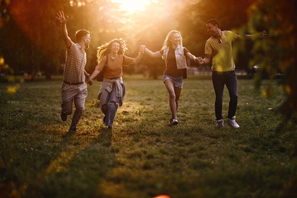 istock Carefree friends having fun while running in nature at sunset. 1471819948