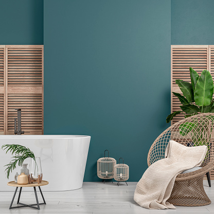 Cozy retro-chic interior with a rattan rounded wicker armchair and a self-standing modern bathtub and faucet in front of a teal blue plaster wall background with copy space. A low coffee table with ceramic containers, vases on the white hardwood floor, birdcage lamps, and decoration (lush foliage: banana/palm tree, pillow, blanket) with 2 hardwood slat doors on each side. The 50s- 60s decoration, art deco style. A slight vintage effect was added. 3D rendered image.