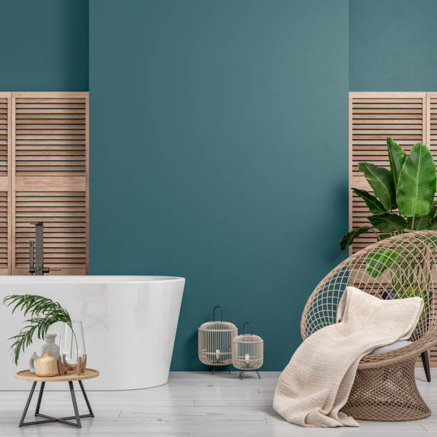 Cozy retro-chic interior with an art deco rattan rounded wicker armchair, bathtub and potted plants, 50s- 60s decoration Cozy retro-chic interior with a rattan rounded wicker armchair and a self-standing modern bathtub and faucet in front of a teal blue plaster wall background with copy space. A low coffee table with ceramic containers, vases on the white hardwood floor, birdcage lamps, and decoration (lush foliage: banana/palm tree, pillow, blanket) with 2 hardwood slat doors on each side. The 50s- 60s decoration, art deco style. A slight vintage effect was added. 3D rendered image. art deco vase stock pictures, royalty-free photos & images