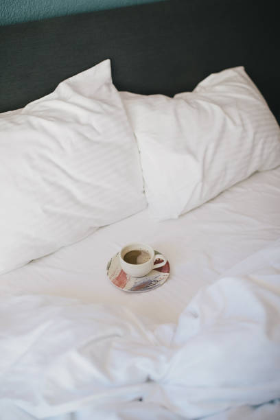 istock Cup of coffee on a white bed in a hotel room. 1471827656