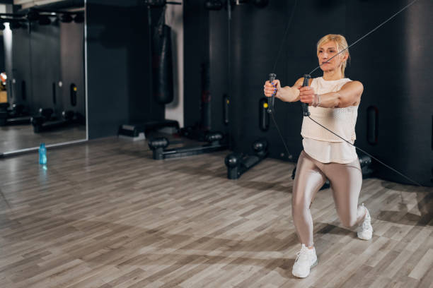 istock A middle age woman is doing exercises to strengthen biceps and triceps using a kinesis machine 1471829741