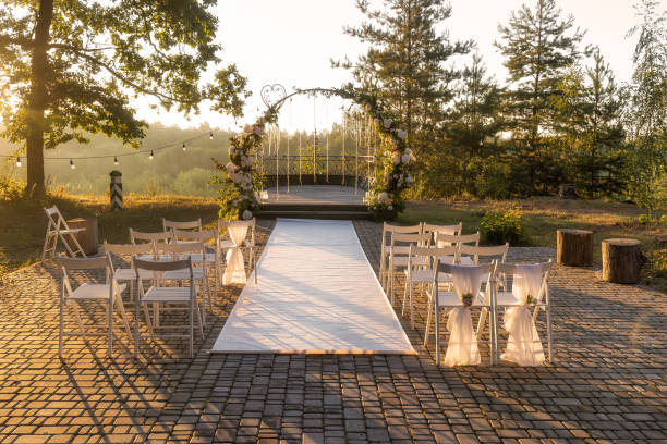 istock Wedding ceremony preparations, rows ofchirs and arch decorated with flowers at sunrise 1471830951