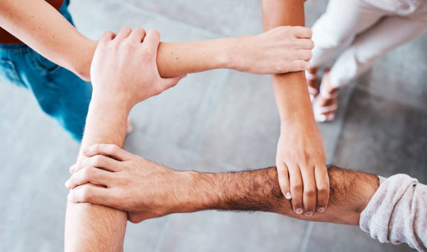 istock Hands, people and support with trust, teamwork and collaboration together for team goal from above. Group diversity in volunteer partnership, social solidarity or community of friends in circle arms 1471835899