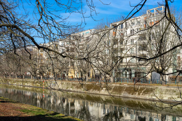 istock Bare Trees At Waterfront Against Buildings In City 1471836502