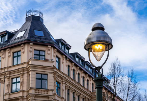 Low Angle View Of Street Light Against Building And Cloudy Sky