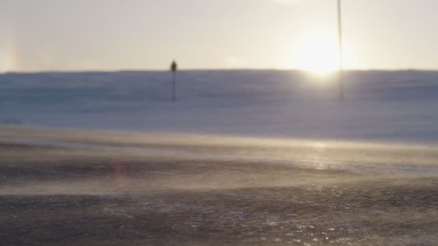 A snow drift over a frozen road
