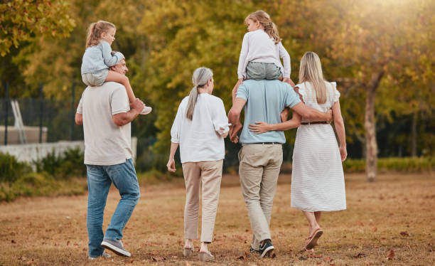 grande família, caminhando e relaxando juntos no parque natural para férias de verão, ambiente de férias e sol ao ar livre. avós, pais e filhos caminham por tempo de qualidade ou laços para a felicidade - large family - fotografias e filmes do acervo