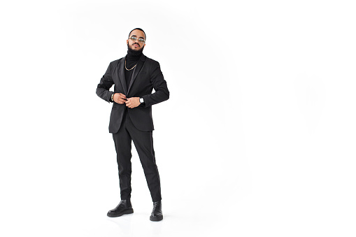 Full body stylish man, posing on white background, wearing black suit with jacket and trousers, blazer turtleneck, glasses and shoes. Fashion male clothing