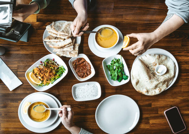 Top view of traditional Turkish soup food with snacks and vegetables on table. People taking various food