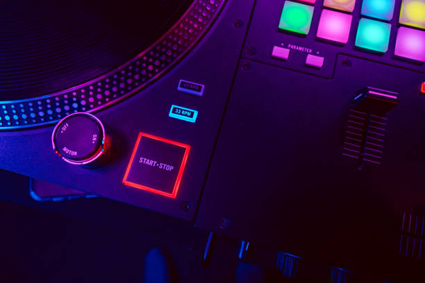 istock Close up of DJ mixing console in party light 1471845895