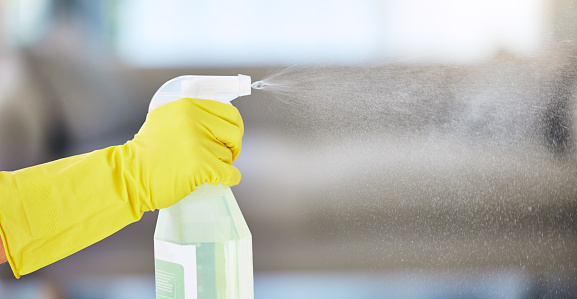 Human Hand Spraying Water With Spray Bottle On Black Background