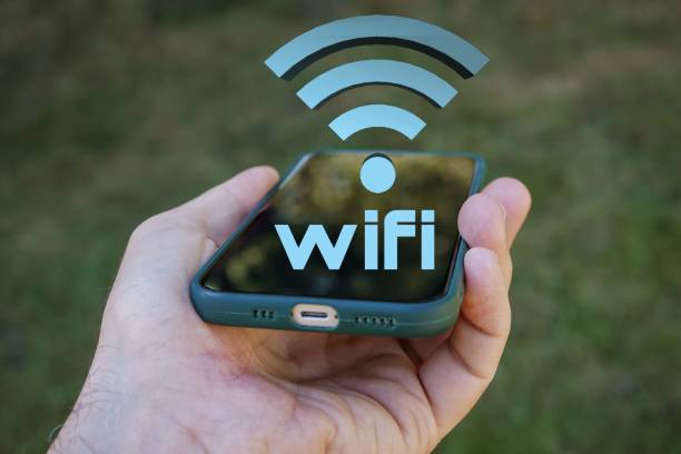 istock hand holding a smart phone with wifi icon, Wireless Fidelity 1471847222