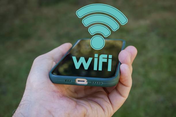 istock hand holding a smart phone with wifi icon, Wireless Fidelity 1471847223