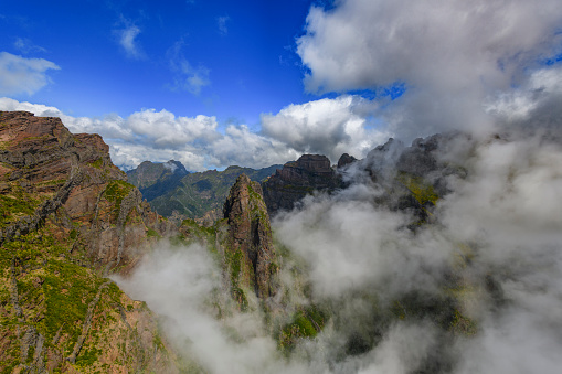 Clouds over the mountains on Madeira island at the Ninho da Manta, or Eagle’s Nest close to the Pico do Arieiro on the Vereda do Areeiro - Pico Ruivo, a populair walkway over the highest mountains of the island.