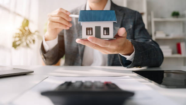 istock Asian businessman holding model home, loan concept. 1471851701