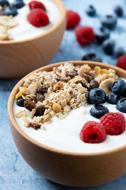 istock Yogurt with berries and muesli for breakfast in bowl on blue background 1471855164