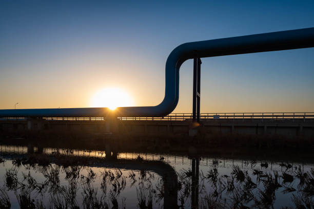Blue pipes going to oil refinery at sunset stock photo