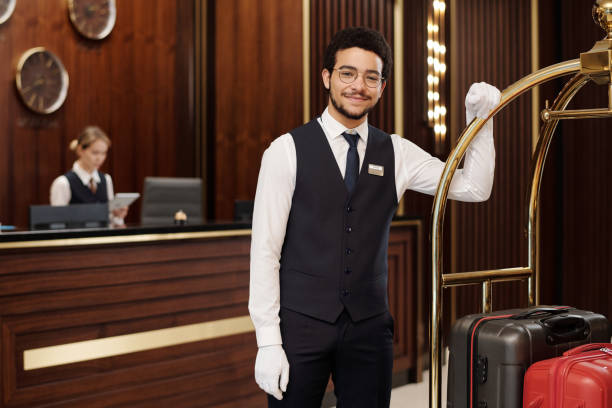 istock Young successful bellboy in elegant uniform and white gloves 1471856526