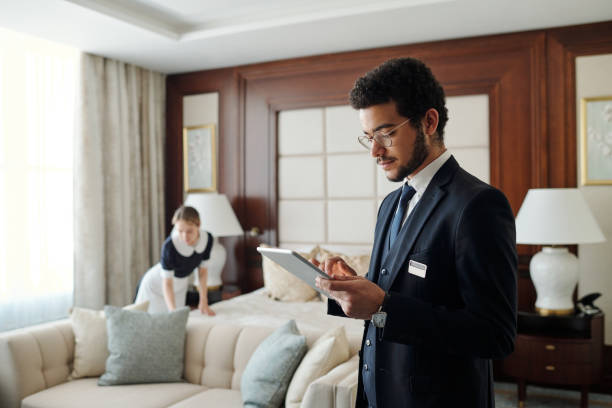 istock Young elegant entrepreneur in formalwear using tablet in hotel room 1471856631