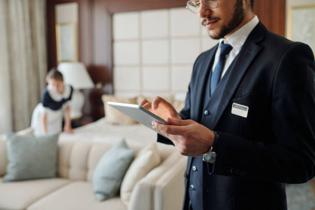 istock Young elegant manager of luxurious hotel using tablet 1471856635
