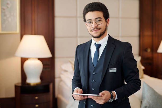 Young confident head manager of luxurious hotel looking at camera stock photo
