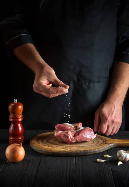 istock The cook sprinkles the meat with salt. Preparing meat before baking. Working environment in restaurant kitchen 1471857683