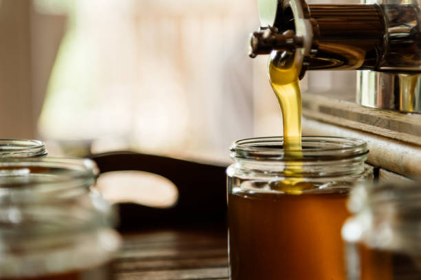 istock gold yellow honey is poured into a jar. 1471858768