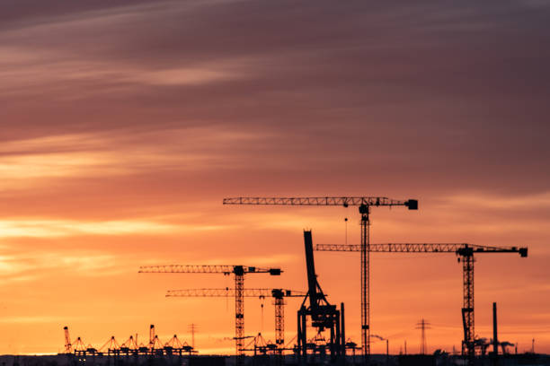 istock Panoramic view of construction cranes in a big city at sunset 1471858785