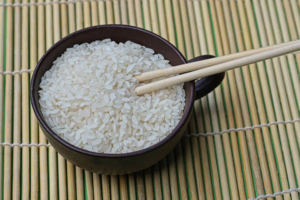 istock one brown cup full of white rice with two wooden sticks 1471859018
